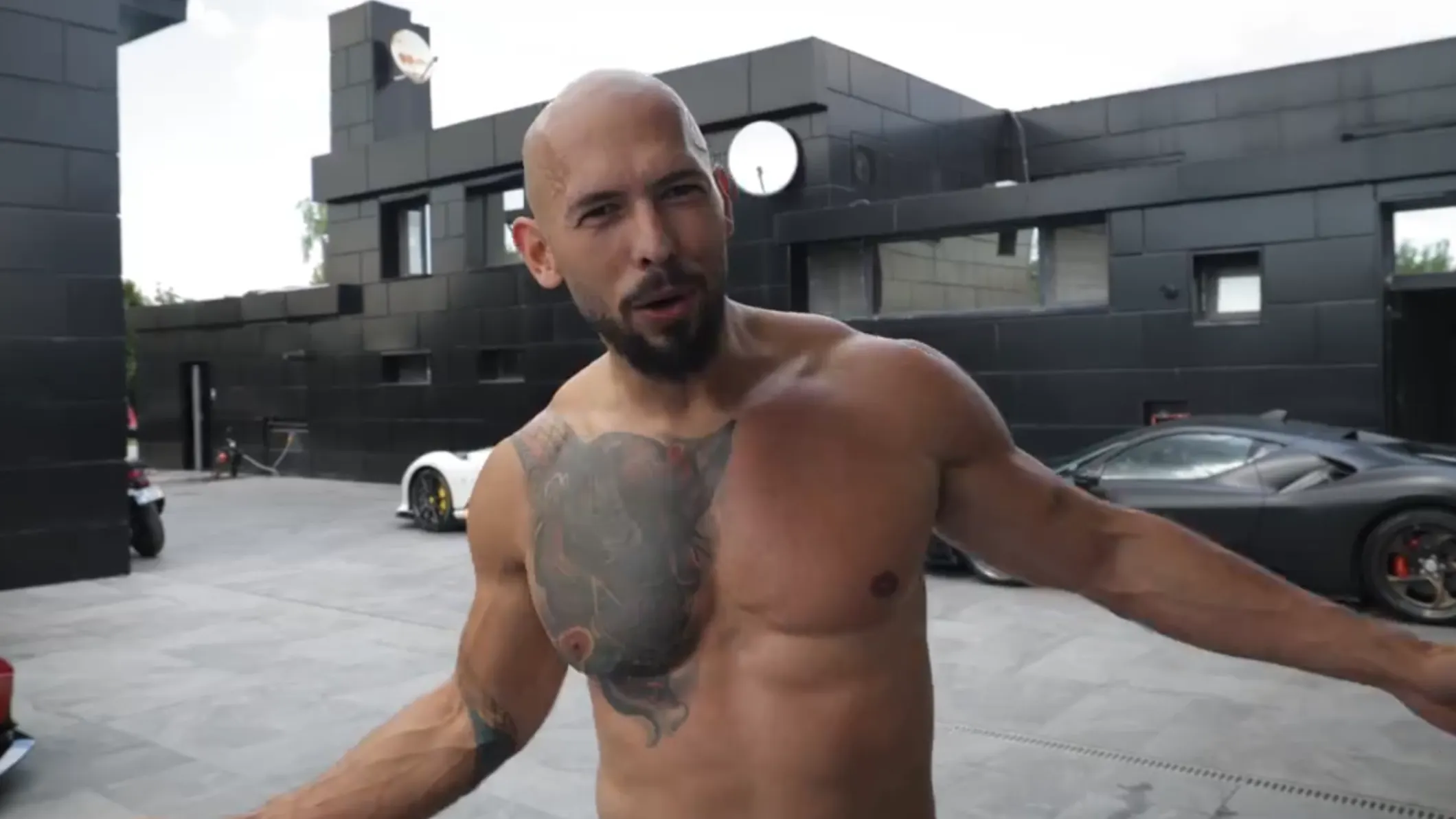 安德鲁·泰特 stands topless at his house in Romania.